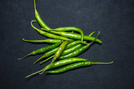 fresh green hot chilli Close-Up on black Background studio shot