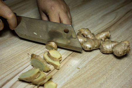 Fresh Raw ginger slice with knife Close-Up on wood board Background studio shotの写真素材