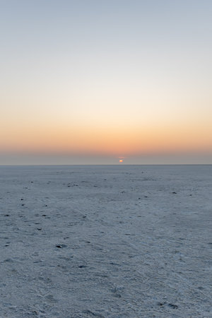 white salt flats desert with dramatic orange sunrise sky at dawn image is taken at dhordo kutch white rann gujrat india.の写真素材