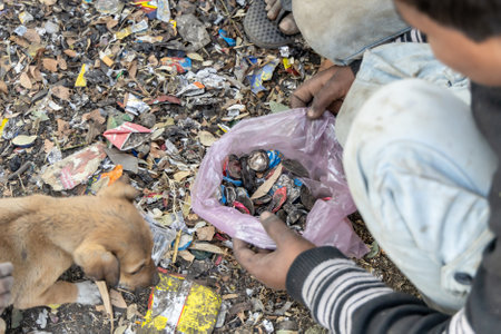 poverty stricken children collecting bottle iron caps for recycle and sale at dayの写真素材