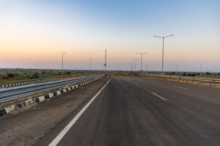 isolated empty tarmac road with bright sunset sky at eveningの写真素材