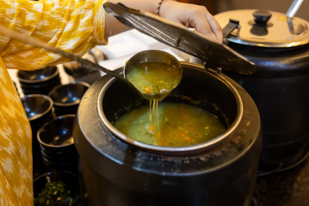 freshly prepared vegetable soup in jar with bowl ready to serve at indoorsの写真素材