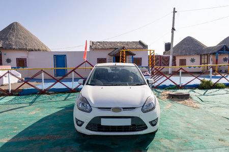 traditional desert camp bamboo hut with car parked in front in natural surroundings with bright skyの写真素材