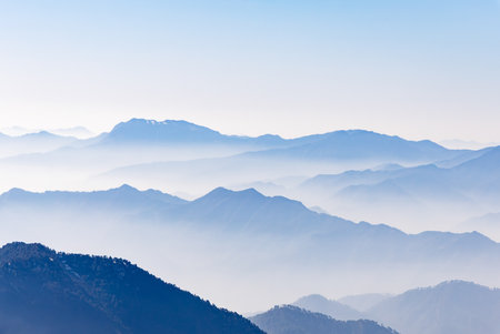 breathtaking mist covered mountain range at morningの写真素材
