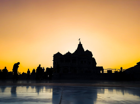 backlit ancient hindu temple architecture with orange bright sunset dramatic sky at dusk image is taken at prem mandir uttar pradesh india.の写真素材