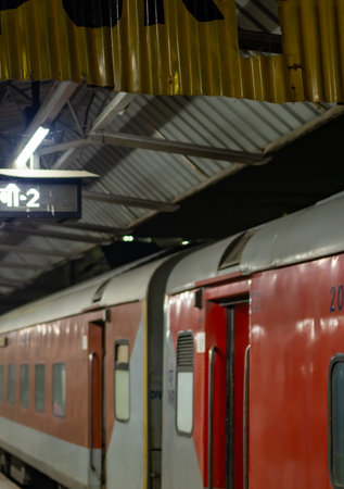 passenger train standing at platform at railway station at eveningの写真素材