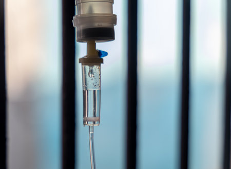 iv drip droplets flowing in tube near hospital windowの写真素材