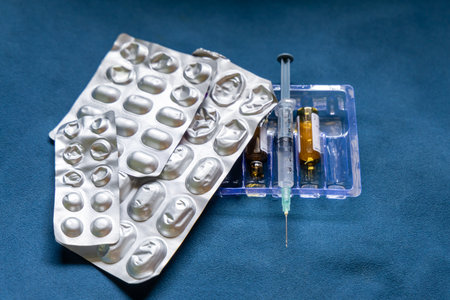 medicine tablet leaf with syringe and empty drug bottle indoorsの写真素材