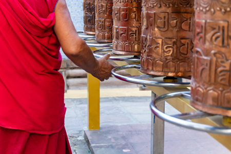 holy monks prying while rotating holy buddhist prayer wheel or mani wheel rolling at monasteryの写真素材