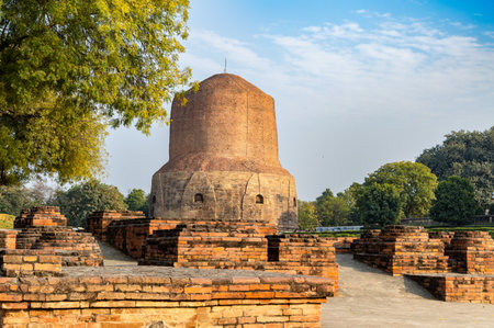 Buddhist ruins with historic sarnath dhamek stupa buddhist heritage monument in day at Sarnath near Varanasi, India, marking the sacred site where Buddha gave his first sermon.の写真素材