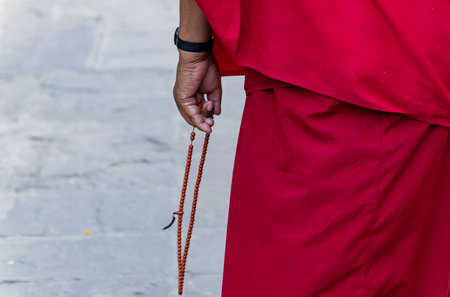 sacred monks performing chanting ritual with garland at monasteryの写真素材