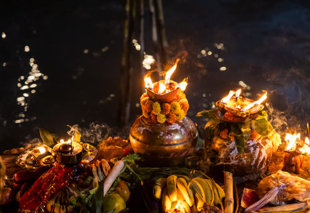 sacred diya offering during holy chhath puja ritual at riverbank
