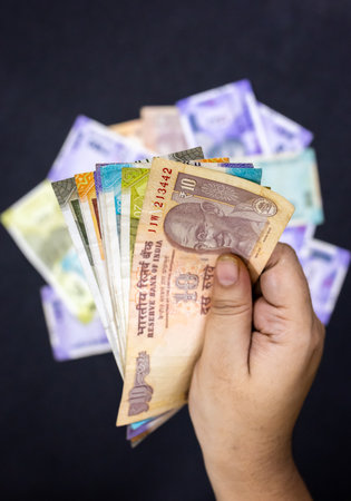 Hand with Indian paper currency showing wealth management Savings And Valueの写真素材