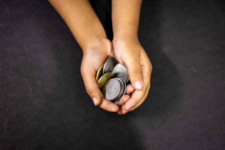 Closeup of child palm with coins concept of financial literacy and managementの写真素材