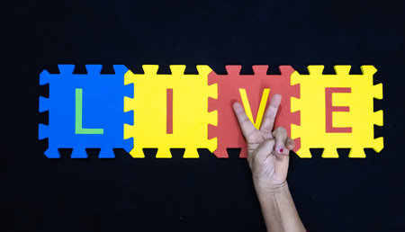 senior hand making v sign for word live over dark backgroundの写真素材