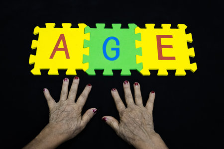 concept of aging or elder years presented with wrinkled hands and letters AGEの写真素材