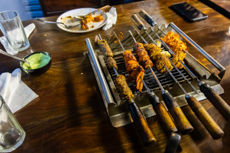 Variety of grilled meat and paneer skewers on open charcoal grillの写真素材
