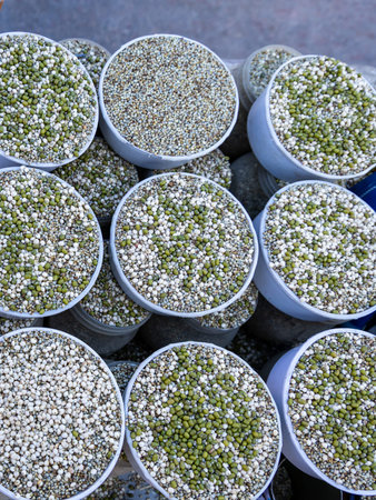 mixed grains and lentils arranged in round containers for sale outdoors for animal feed