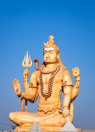 shiva deity statue bearing trishul damru om sign under bright daylightの写真素材
