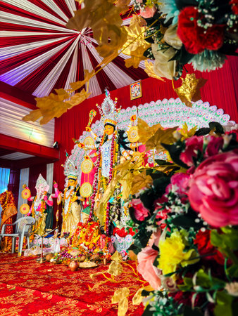 vibrant durga maa statue with ornate backdrop and garlands from unique perspectiveの写真素材