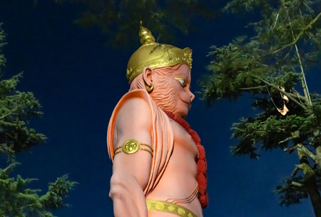 majestic hanuman statue standing tall in temple grounds at nightの写真素材
