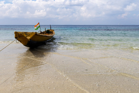 quiet seaside scene with anchored boat and gentle wavesの写真素材