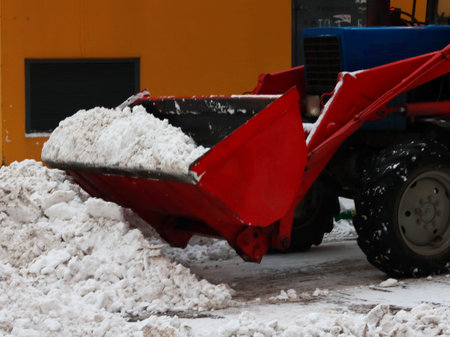 red tractor cleans the snow
