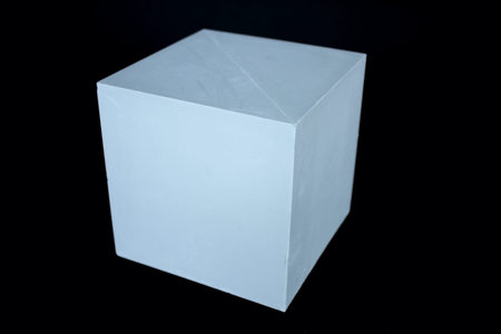 Plaster figure cube isolated on the black background.