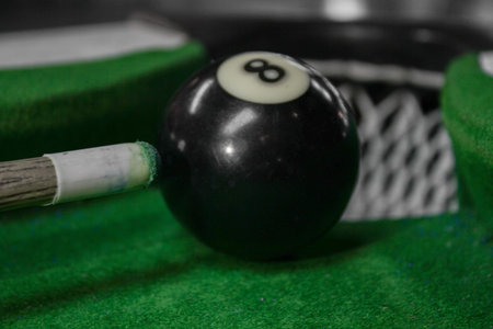 Billiard ball number eight. Close up view. Green background