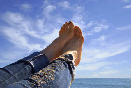 feet of beach land raised pointing the skyの写真素材