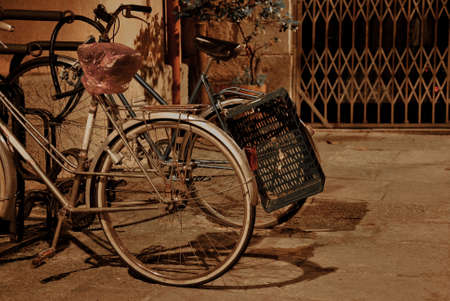 vintage bicycles parked on a street at night alone andの写真素材