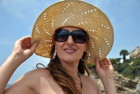 woman with hat and sunglasses on the beachの写真素材