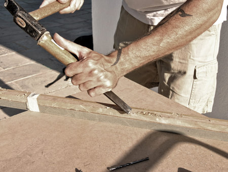 arms of a carpenter working with wood