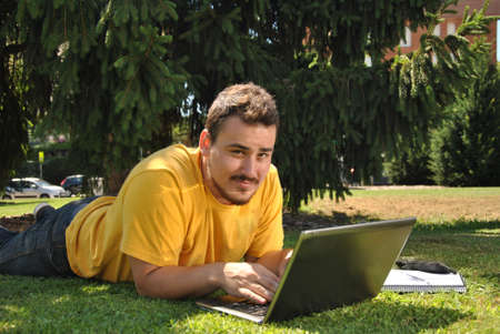 college student lying on the grass in the sunの写真素材