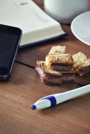 office table with pieces of cake and scheduleの写真素材