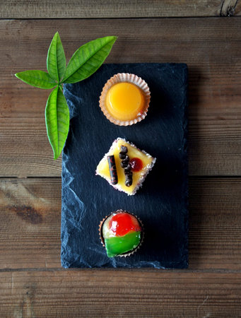 small sweet cakes with cup of coffee on wooden tableの写真素材