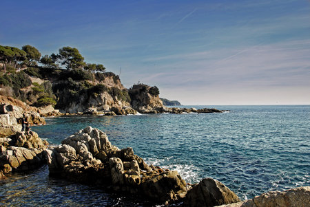 Sunrise on a beach full of rocks in Lloret de Mar