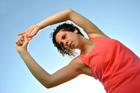 Young woman doing stretching on the grass after sports
