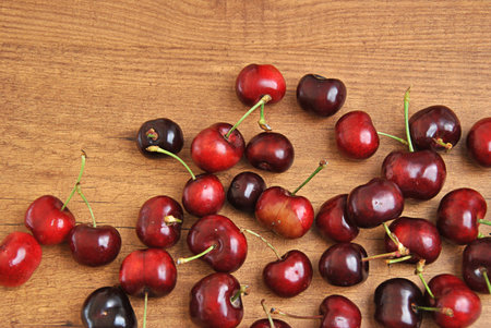 many cherries in a white bowl on a tableの写真素材