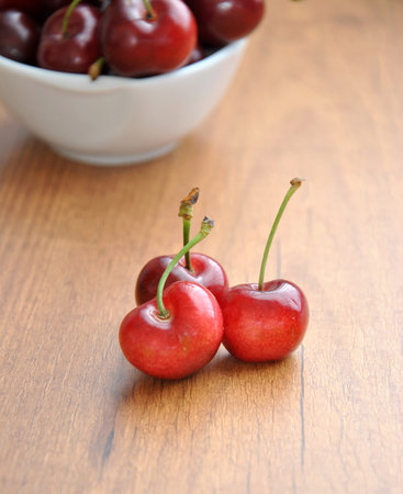 many cherries in a white bowl on a table