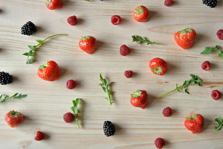 Aerial photo of raspberries, strawberries and blackberries on a wooden backgroundの写真素材