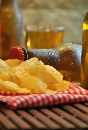 bottles of cold beer and chips on wooden tableの写真素材