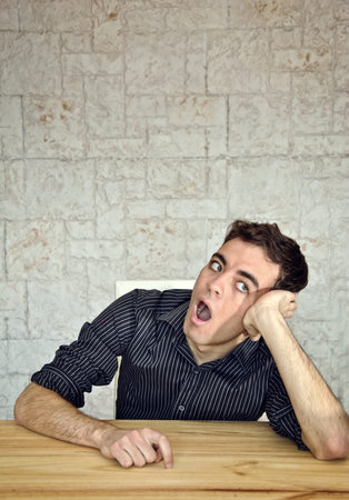 young guy getting facial expressions in his officeの写真素材