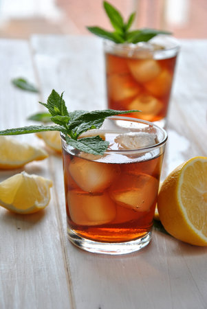 glasses of ice tea with mint leaf on wooden tableの写真素材