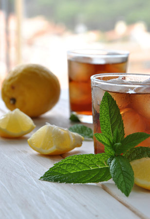 glasses of ice tea with mint leaf on wooden table