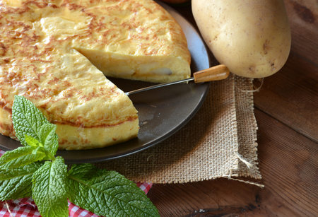 Spanish omelette with potato and egg, accompanied by olive oil