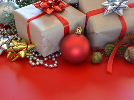 Christmas decorations accompanied by gifts, pines and balls on wooden table