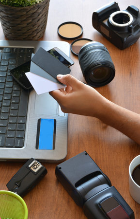 desktop with photography equipment, camera, tripod,flash  and computer