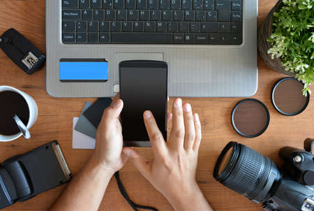 desktop with photography equipment, camera, tripod,flash  and computerの写真素材