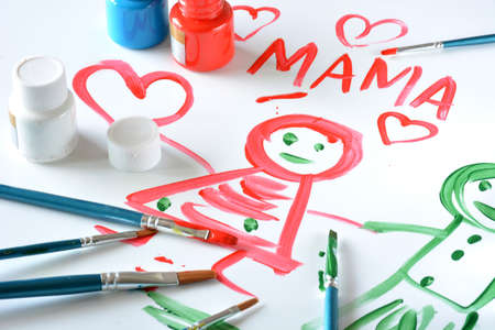 watercolors and brushes with children's drawings on white canvasの写真素材